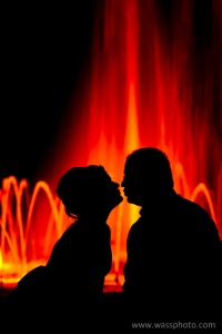 Couple silhouette in front of fountain at night