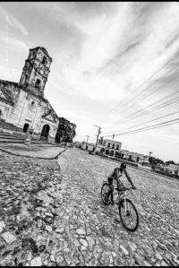 Kid riding a bike in front of a church