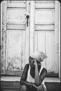 Cuban woman sitting in front of the door in the streets of Trinidad, Cuba