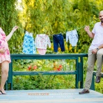 Couple holding baby clothes during maternity session