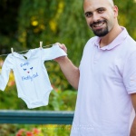Daddy holding shirt of baby during maternity session