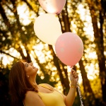 Pregnant holding balloons