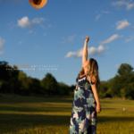 Pregnant woman throwing her hat in the air